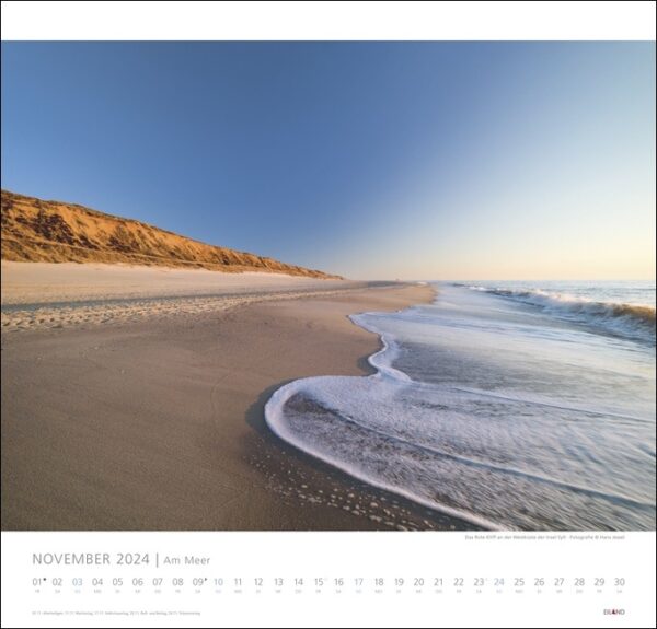 Ein Kalender, der eine faszinierende Strandszene mit Wellen und Sand zeigt und die Gelassenheit von Am Meer 2024 einfängt.