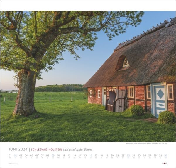 Ein Kalender mit einem Reetdachhaus inmitten der malerischen Felder Schleswig-Holsteins 2024, vor dem Hintergrund des Jahres 2024.