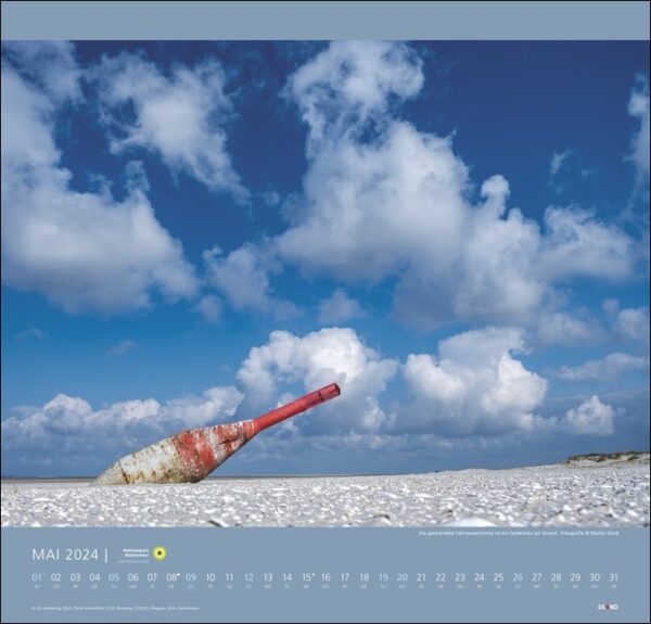 Ein Kalender mit einem roten Nationalpark Wattenmeer 2024 am Wattenmeerstrand.