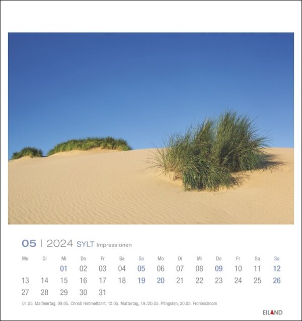 Ein Sylt Impressionen - PostkartenKalender 2024, der Sanddünen vor einem atemberaubend blauen Himmel zeigt.