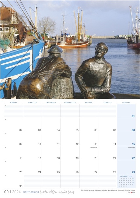 Ein Kalender mit zwei Statuen vor einem Boot in Ostfriesland 2024.