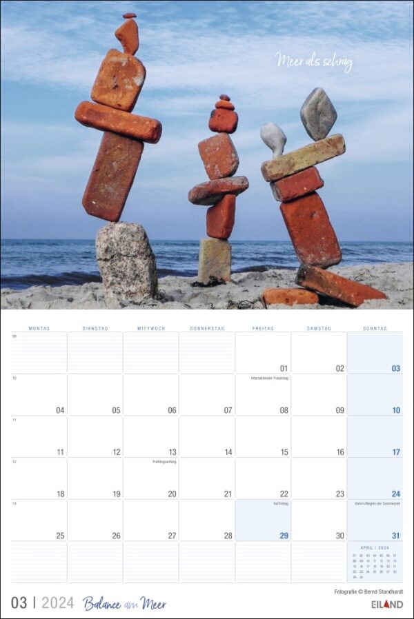 Ein Kalender mit kunstvoll am Strand arrangierten Felsen, die eine ruhige Balance am Meer 2024 zwischen Natur und Zeit schaffen.