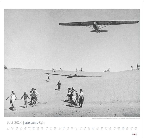 Ein Schwarz-Weiß-Foto eines Flugzeugs, das über einer Sanddüne in MEIN ALTES Sylt fliegt - Bleicke Bleicken 2024.
