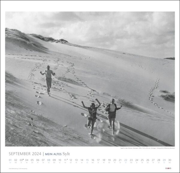 Ein Schwarz-Weiß-Foto von Menschen, die am Sandstrand von MEIN ALTES Sylt - Bleicke Bleicken 2024 laufen.