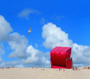 Ein Küste – Sommerstuhl, der auf einer Sanddüne an der Küste sitzt.