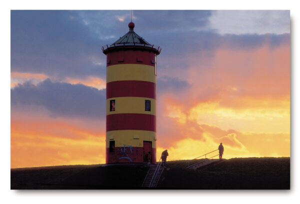 Eine gelb-rote Serie Leuchttürme - Pilsum/Ostfriesland auf einem Hügel bei Sonnenuntergang in Ostfriesland.