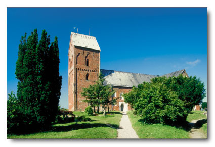 Eine Kirche mit einem Kirchturm mitten auf einem Feld auf Meine Insel - Nieblum auf Föhr - St. Johannis Kirche.