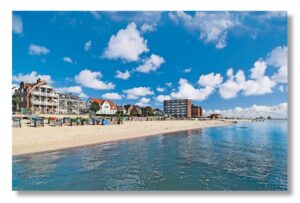 Ein Bild eines Strandes mit Häusern und blauem Himmel auf Föhr - Meine Insel -.