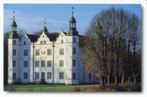 Ein großes weißes Gebäude mit Uhrturm, Schleswig-Holstein - Ahrensburger Schloß.