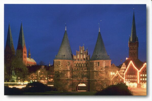 Eine Stadt bei Nacht mit Burg und Türmen in Schleswig-Holstein - Holstentor - Historische Stadtansicht von Lübeck.