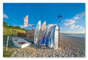 Eine Gruppe Sylt Impressionen – Surfer’s Paradiese reihen sich am Strand von Sylt, einem der Surfer’s Paradise, auf.