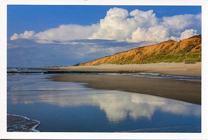 Ein Strand mit Wolken, die sich im Wasser spiegeln, bei Sylt Impressionen.