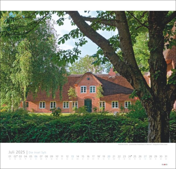 Eine Kalenderseite von „Die Insel Sylt 2025“ mit einem rustikalen Backsteinhaus auf der Insel Sylt, umgeben von üppigem Grün, mit einem Teilblick auf das Haus, das hinter großen Bäumen versteckt ist.