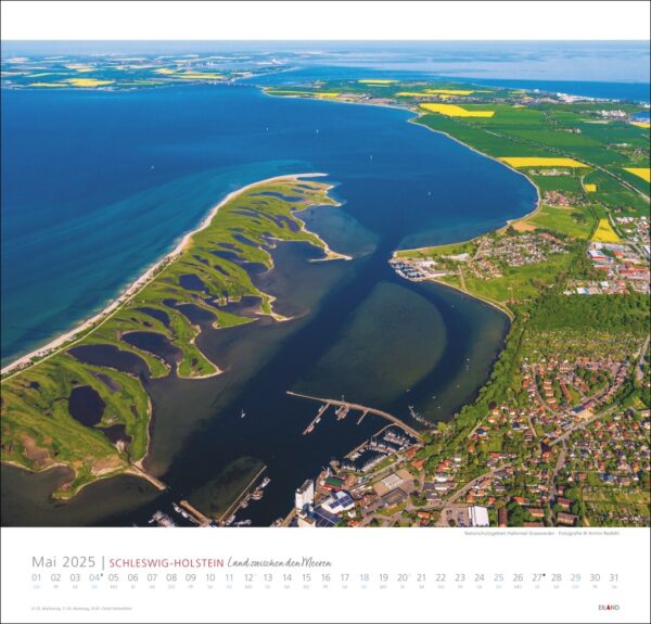Luftaufnahme einer Küstenstadt in Schleswig-Holstein, Deutschland, mit einem Schleswig-Holstein-Kalender 2025. Das Bild zeigt einen Fluss, der ins Meer mündet, mit einem Yachthafen.
