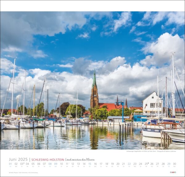 Ein Kalenderblatt für Schleswig-Holstein 2025 mit einer malerischen Szene aus Schleswig-Holstein mit einem Yachthafen voller Segelboote im Vordergrund und einer markanten Kirche mit einem hohen grünen Turm darunter.