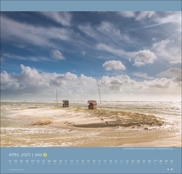 Ein Nationalpark Wattenmeer-Kalender 2025 mit einer ruhigen Strandszene im Nationalpark Wattenmeer mit zwei farbenfrohen, rustikalen Fischerhütten an Sandstränden unter einem weiten, bewölkten Himmel. Sanfte Wellen schlagen an die