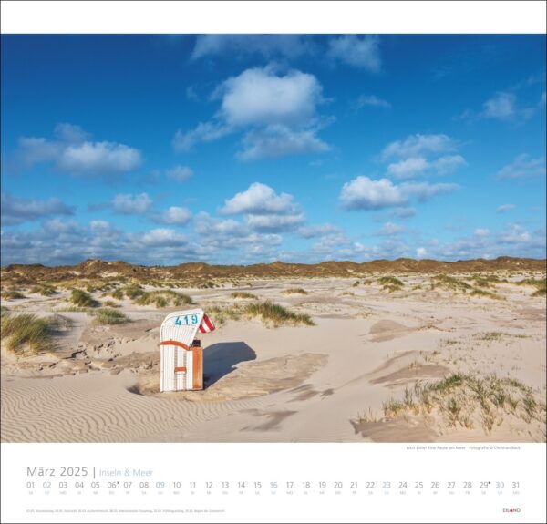 Ein malerisches Bild einer einsamen Rettungsschwimmerhütte mit der Nummer 418 an einem Sandstrand mit üppigen Dünen unter einem weiten blauen Himmel, verwendet als Inseln & Meer-Kalender 2025 am Meer.