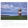 Eine Seite des Leuchttürme - PostkartenKalender 2025 mit dem Bild eines kräftigen Leuchtturms, der in der Dämmerung von warmem Licht erhellt wird, mit einem dramatischen Wolkenhimmel und einer dezenten Küstenlinie im Hintergrund. Der Kalender zeigt Daten in