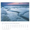 Eine Watt’n Meer – PostkartenKalender-Seite für den Januar 2025 mit einer ruhigen Dämmerungsszene mit einem verschneiten Strand und eiskaltem Wasser unter einem Himmel in rosa und blauen Farbtönen und dem Titel „Watt’n Meer im Nationalpark“.