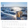 Dieses Bild zeigt eine Seite des Watt’n Meer - PostkartenKalenders 2025 für Dezember mit einer herzförmigen, geöffneten Muschel an einem Sandstrand, Wasser in der Nähe und der Sonne, die tief am Himmel scheint und ein … erzeugt.
