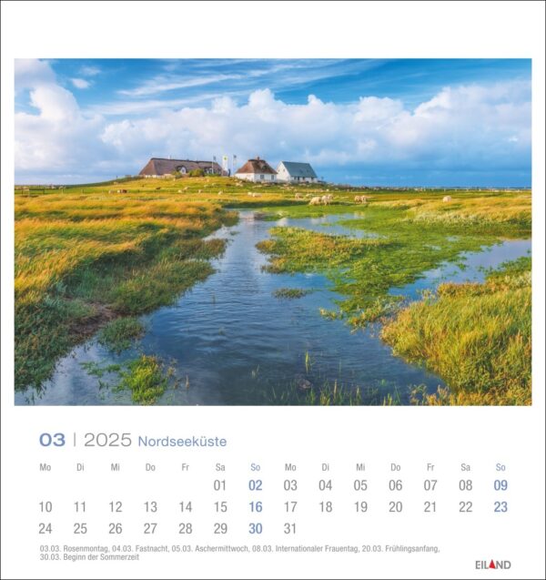 Eine Nordseeküste - PostkartenKalender-Seite für März 2025 mit einer ruhigen Küste, mit einem von üppigem Grün umgebenen Wasserkanal, in der Ferne traditionellen Häusern unter einem blauen Himmel mit flauschigen Wolken.