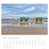 Zwei Wattwagenfahrten zur Hallig Südf. (Nordseeküste - PostkartenKalender 2025) mit Touristen unter einem bewölkten Himmel an der Nordseeküste.