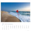 Ein Nordseeküste – PostkartenKalender 2025 mit einem Bild der Nordseeküste mit einer roten Warnflagge und einem Schild, rauer See und einer Mondsichel am Himmel.