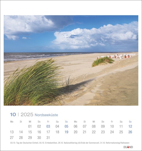 Eine *Nordseeküste - PostkartenKalender 2025*-Seite für Oktober mit einer ruhigen Strandszene an der Nordsee, mit Dünengras im Vordergrund und einer Reihe von Strandkörben entlang des Sandufers darunter.