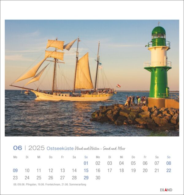 Eine Ostseeküste - PostkartenKalender 2025-Seite für Juni 2025 mit einem großen Segelschiff mit zwei Masten und mehreren Segeln in der Nähe eines grünen Leuchtturms an der Ostseeküste. Die Szene wird von warmem Sonnenlicht beleuchtet.