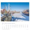 Ostfriesland einfach schön – PostkartenKalender-Seite für Januar 2025 mit einer verschneiten Szene in Ostfriesland. Im Vordergrund sitzt eine Statue mit zwei Figuren auf einer Bank und blickt auf einen zugefrorenen Kanal.