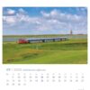 Eine lebendige Seite im PostkartenKalender 2025 „Ostfriesland einfach schön“ mit einem rot-blauen Zug, der durch eine üppig grüne Landschaft unter einem weiten Himmel fährt, mit einem entfernten Kirchturm, für Juli.