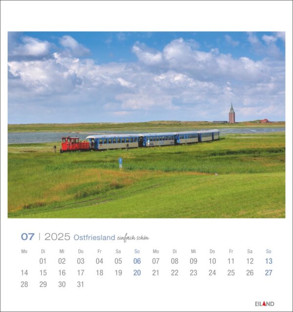 Eine lebendige Seite im PostkartenKalender 2025 „Ostfriesland einfach schön“ mit einem rot-blauen Zug, der durch eine üppig grüne Landschaft unter einem weiten Himmel fährt, mit einem entfernten Kirchturm, für Juli.
