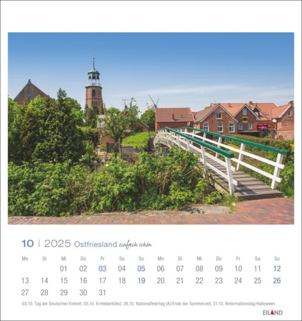 Der Ostfriesland einfach schön - PostkartenKalender 2025 für Oktober zeigt eine malerische Aussicht auf Ostfriesland mit rot gedeckten Häusern und einer Kirche mit grünem Turm. Im Vordergrund ein