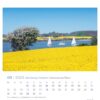 Eine Schleswig-Holstein - PostkartenKalender 2025 Seite für den Mai mit einer lebendigen Landschaftsszene aus Schleswig-Holstein. Das Foto zeigt im Vordergrund ein blühendes gelbes Rapsfeld.