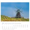 Eine Juni-Kalenderseite aus dem Schleswig-Holstein - PostkartenKalender 2025, mit einer traditionellen Windmühle in Schleswig-Holstein, Deutschland. Die Windmühle steht auf einem grasbewachsenen Hügel mit
