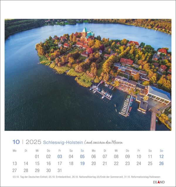 Luftaufnahme einer üppigen, bewaldeten Insel in Schleswig-Holstein - PostkartenKalender 2025 mit einem großen, historischen Gebäude mit rotem Dach und mehreren Nebengebäuden, umgeben von Wasser mit einem Dock und