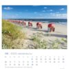 Ein Usedom - PostkartenKalender 2025 für Juni zeigt einen ruhigen Strand auf der Insel Usedom mit einer Reihe von Strandkörben entlang der Küste mit Blick auf das Meer.
