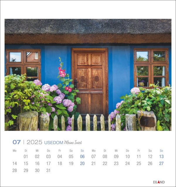 Auf einer Seite des Usedom - PostkartenKalender 2025 für Juli ist ein charmantes Haus mit Strohdach und Holztür zu sehen, flankiert von üppigen Hortensien. Es ist ein traditionelles Haus im deutschen Stil und zeigt
