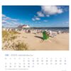 Eine Usedom - PostkartenKalender 2025-Seite für August, die eine ruhige Strandszene auf der Insel Usedom zeigt. Es gibt Reihen von Strandkörben am Sandstrand, in der Ferne ein Gebäude unter einem.