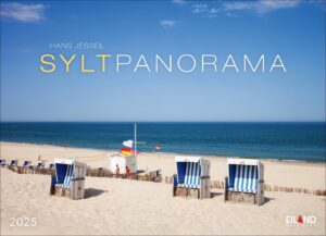 Ein malerischer Blick auf den Strand unter einem klaren blauen Himmel. Mit blau-weiß gestreiften Strandstühlen vom Typ Sylt Panorama 2025, die im Sand aufgereiht sind, und einer rot-weißen Rettungsschwimmerstation mit Blick auf das ruhige Meer.