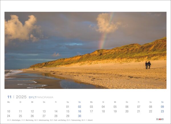 Eine Kalenderseite für das Sylt Panorama 2025 mit einem Sylt-Panorama bei Sonnenuntergang mit einem partiellen Regenbogen im Hintergrund. Zwei Menschen laufen unter einem bewölkten Himmel auf dem Sand in der Nähe von grasbedeckten Dünen.