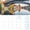 Eine Kalenderseite für Hamburg …meine Perle 2025 mit dem Bild einer Brücke in Hamburg, Deutschland, bekannt als „Hamburg, meine Perle“, mit einem darüberfahrenden Zug und ruhigem Wasser darunter, in dem sich die