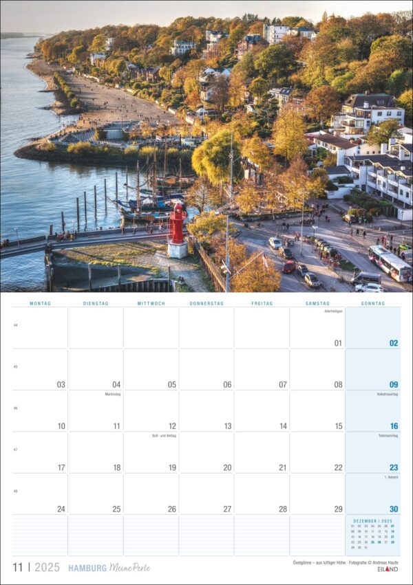Eine Hamburg ...meine Perle 2025-Kalenderseite für November mit einer ruhigen Luftansicht der Hamburger Küste mit einem kleinen roten Leuchtturm, in einem Yachthafen ankernden Booten, von Bäumen gesäumten Straßen und Häusern am Strand.