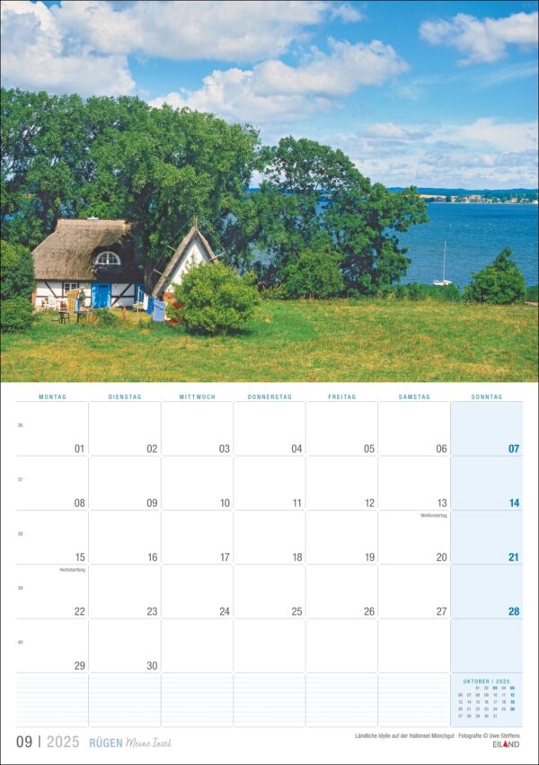 Ein Kalenderblatt „Rügen …meine Insel 2025“ für September mit einer malerischen Aussicht auf ein Reetdachhaus an einem See auf Rügen, umgeben von üppigem Grün und einem klaren blauen Himmel, mit Daten.