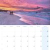 Eine Usedom …meine Insel 2025-Kalenderseite für Februar mit einem ruhigen Sonnenuntergang am Strand von Usedom. Himmel in Rosa- und Lilatönen über Silhouetten von Menschen, die auf dem Sand laufen. Kalenderdaten überlagert