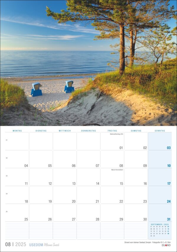 Eine Kalenderseite für Usedom …meine Insel 2025 mit einer ruhigen Strandszene auf Usedom mit zwei blauen Liegestühlen mit Blick auf das Meer, umgeben von Sand, Gras und einer großen Kiefer an einem klaren sonnigen