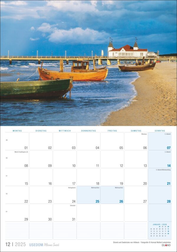 Eine Kalenderseite mit dem Titel „Usedom, meine Insel 2025“ mit einem Bild der Küste Usedoms, auf dem traditionelle Boote an Sandstränden, ein leuchtender Himmel und ein entferntes Gebäude unter einem bedrohlich bedeckten Himmel zu sehen sind.