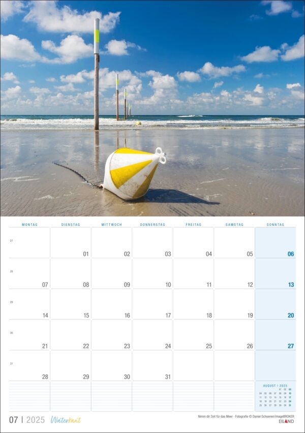 Eine Waterkant-Kalenderseite 2025 für Juli mit einer ruhigen Waterkant-Szene, die ein gelb-weißes Boot auf nassem Sand und drei vertikale Stangen im Hintergrund unter einem bewölkten Himmel zeigt.