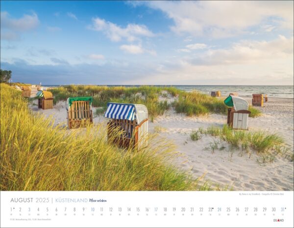 Ein Küstenland - Meer erleben 2025 August Kalenderbild mit einer ruhigen Strandszene in Küstenland, mit verstreuten Strandkörben auf Sanddünen. Sanfte Wellen vom Meer erleben treffen das Ufer unter einem