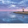 Ein heiterer Kalender für Küstenland - Meer erleben 2025 mit einer Dämmerungsszene im Küstenland. Im Vordergrund ein Leuchtturm auf einem schmalen Landstreifen, umgeben von ruhigem Wasser, das das zarte Rosa und